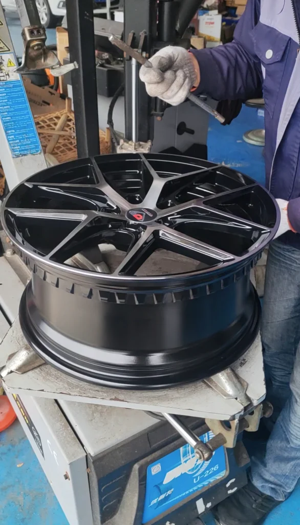 Close-up view of an AEGIS RIM Gripsafe hub being mounted onto a standard tire changing machine, demonstrating the compatibility with conventional shop equipment.